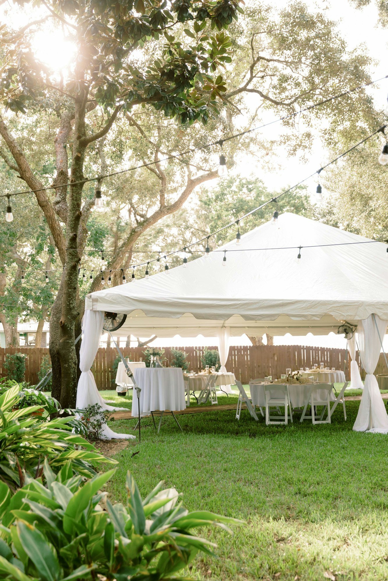 Scenic shot of a white tent in a wedding venue and chairs and tables under it